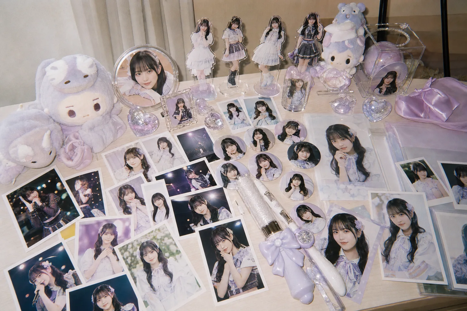 机いっぱいに並んだ既存の推し活グッズ。写真もぬいぐるみもすべて量産品